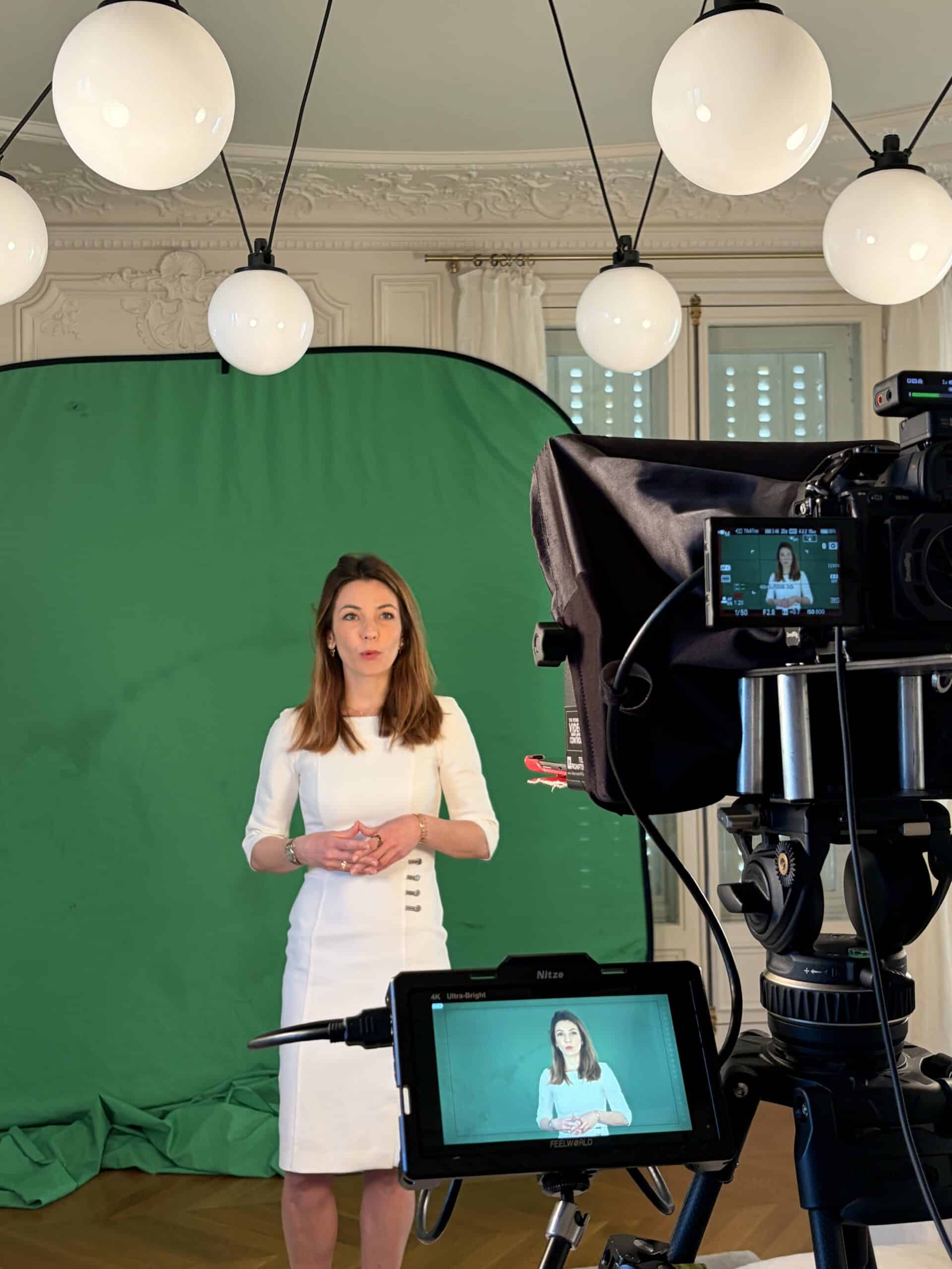 Responsable d'entreprise en tournage d'interview vidéo sur fond vert, filmée par une équipe professionnelle.